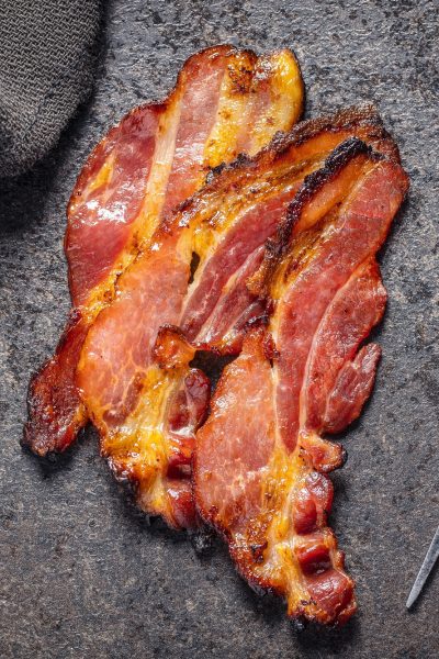 Fried bacon. Sliced roasted bacon.